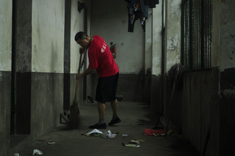 集聚萤火·与爱同行，2011徒步湘江毅行：一位晚报义工人员在学校露营处打扫卫生